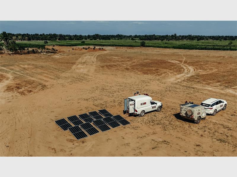 solar panels and vehicles in an open sandy area