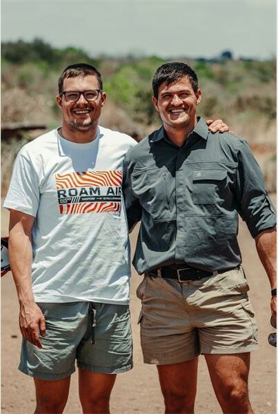 two men stand in a sandy plain