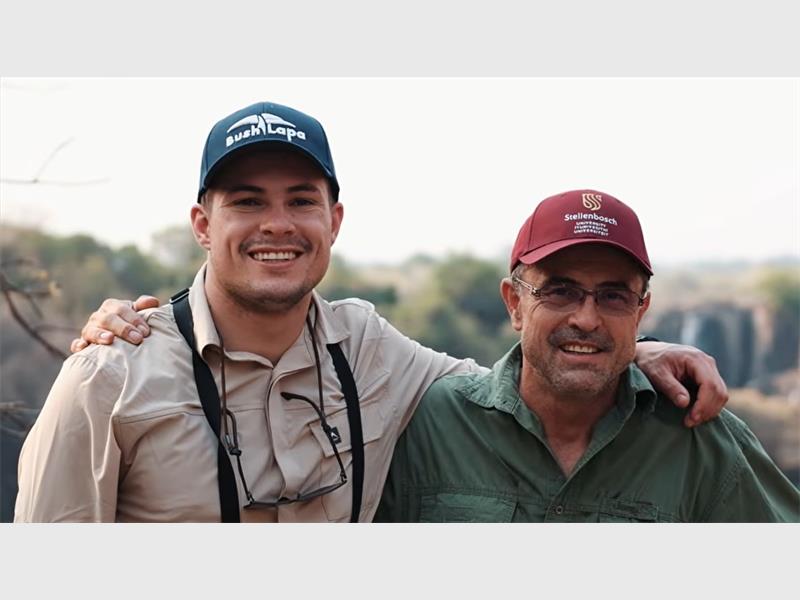 A young man with a cap and kakhi shirt with his arms around a n oldrer man