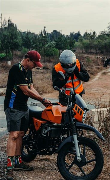 two men work over a motorcycle