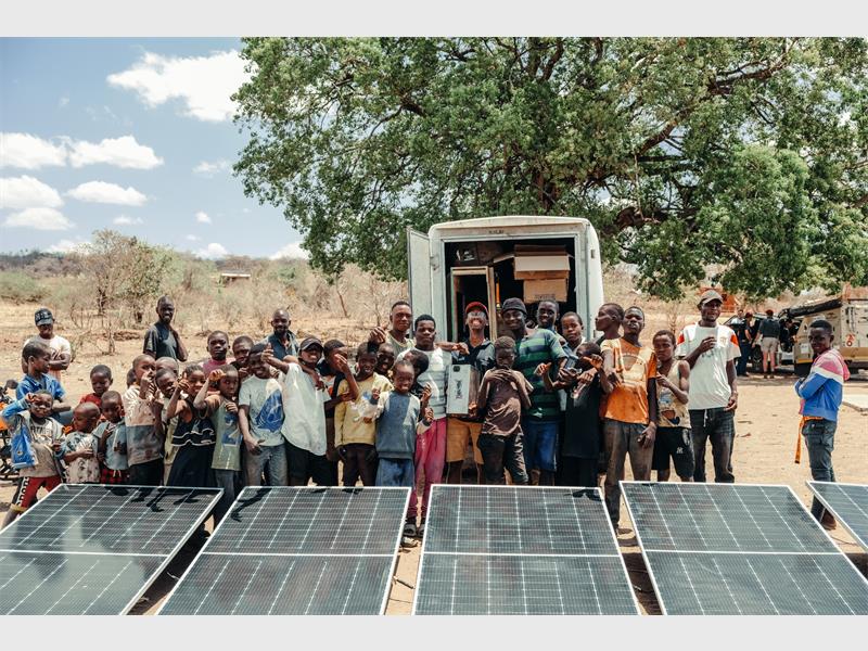 a large group of people with solar panels in the foreground