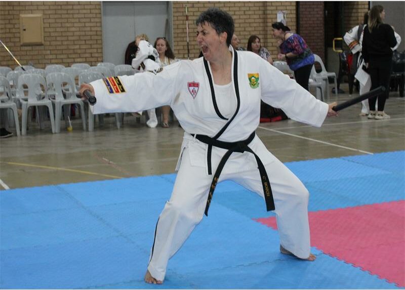 woman in martial arts outfit on blue and red mats