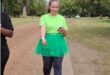 woman in green tutu walks on a gravel road