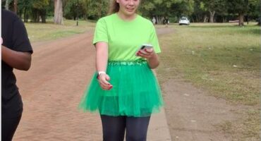 woman in green tutu walks on a gravel road