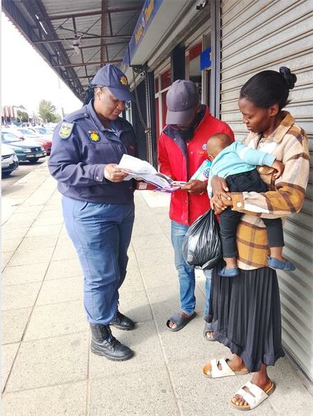 police woman speaks to a couple with a baby