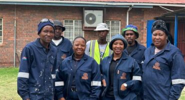 a work crew in blue coveralls