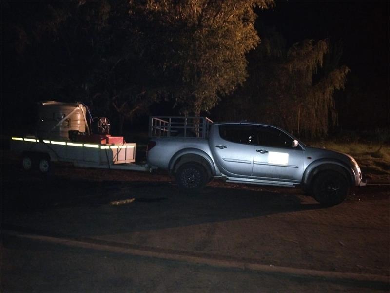 a bakkie pulls a trailer with a jo jo tank on top in the dark