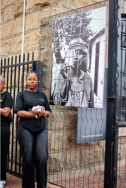 a woman in front of a picture of woman with a pass book