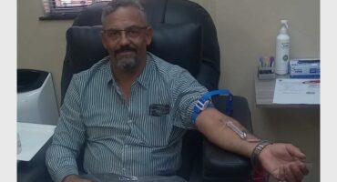 Blood donation man at clinic, donating blood in a medical setting.