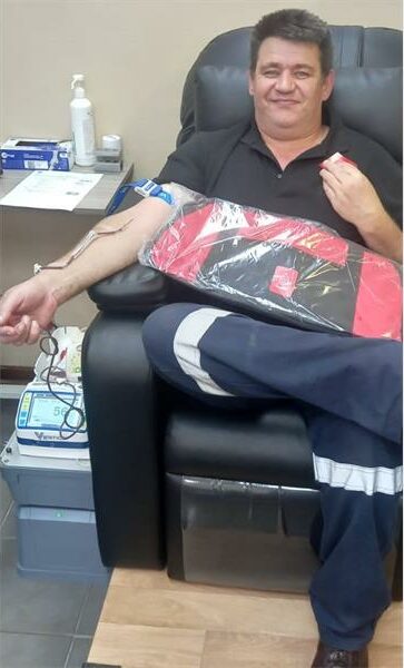 Blood donation process with a smiling donor in a medical setting.