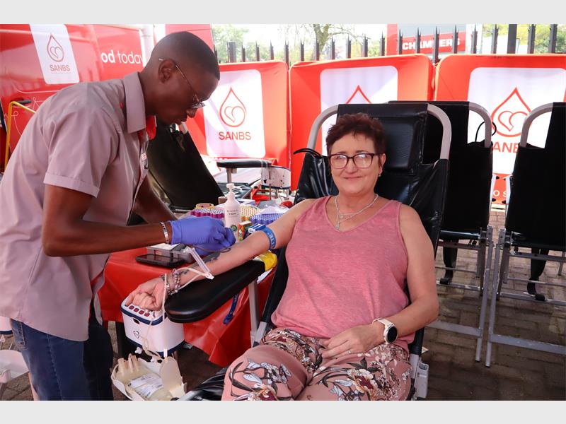 male nurse is preparing female donor for her blood donation