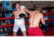 two young men in the middle of a boxing bout
