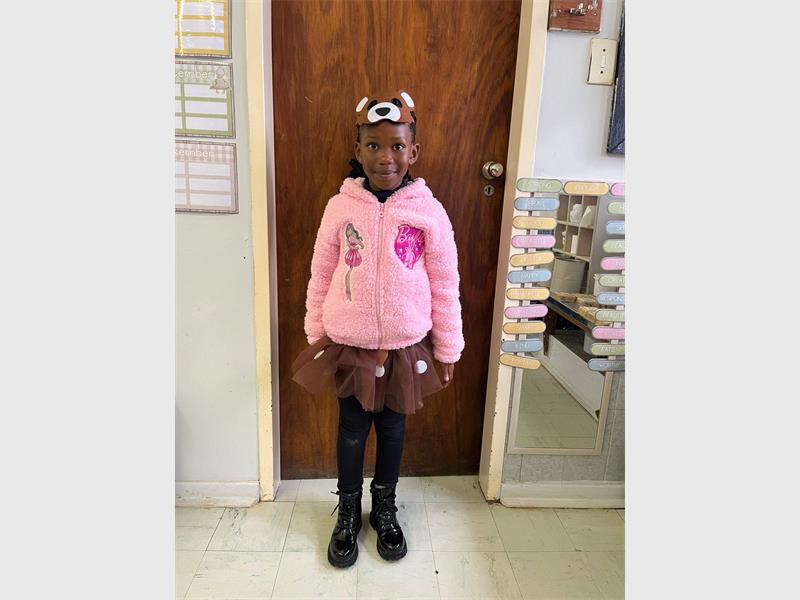 Girl is dressed as a pink bear.