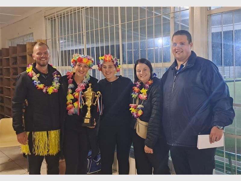 Celebrating success with a group of smiling individuals wearing colourful leis and floral crowns, ho.