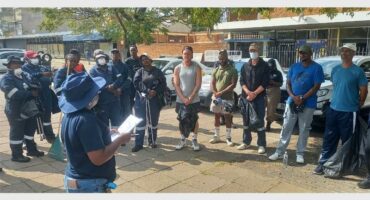 Community members gather outdoors for a meeting in Ridge Times.