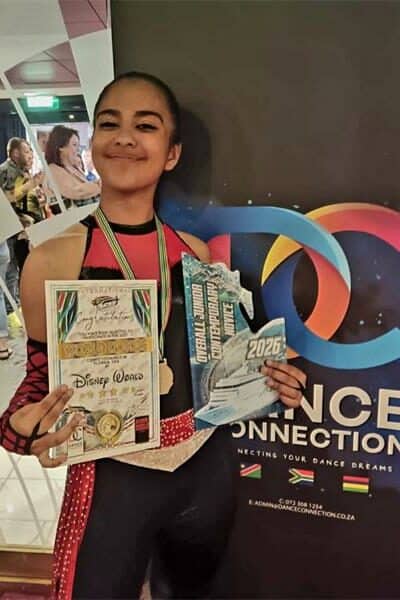 girl in black and red dance clothes holds trophy and certificate