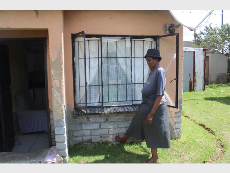 A woman is standing outside a house