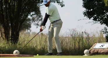 Golf player preparing to tee off on a sunny day at the golf course.