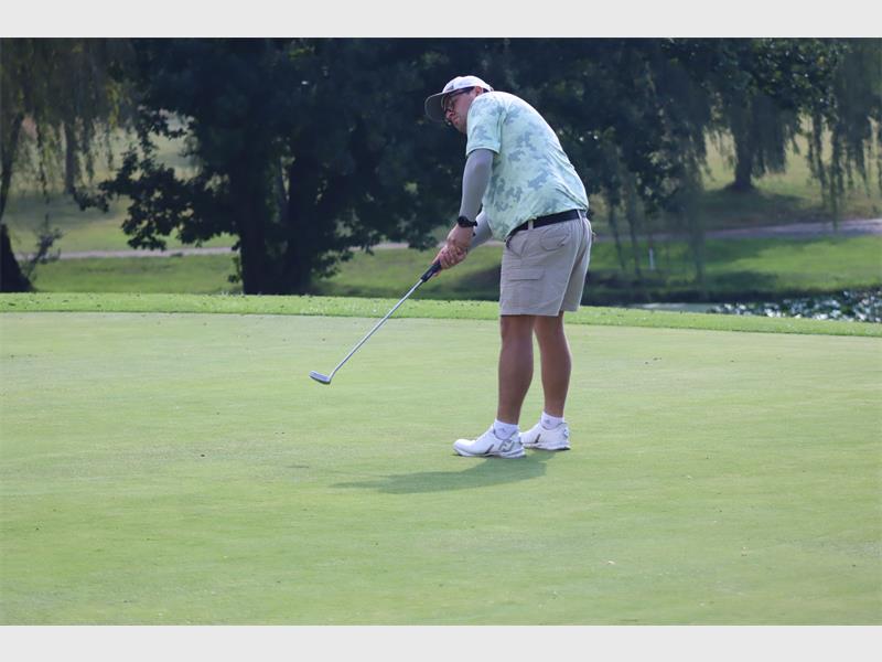 Golf player putting on the green at a golf course.