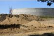a water reservoir with heaps of sand in the front