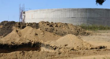 a water reservoir with heaps of sand in the front