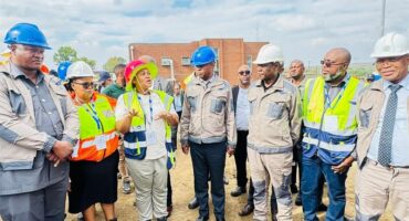 people with overalls and hard hats on a construction site