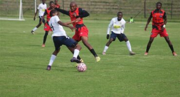 soccer players tackle each other