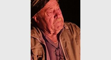 an elderly man with a hat on his head