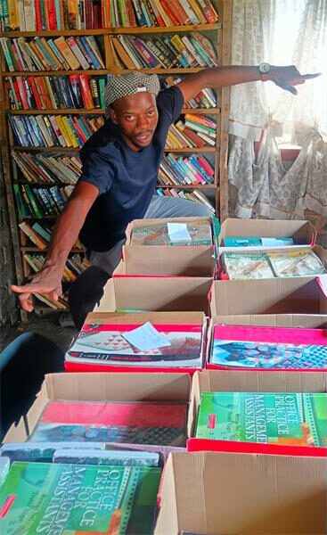 Book donation event at Ridge Times, featuring a woman arranging books for distribution.