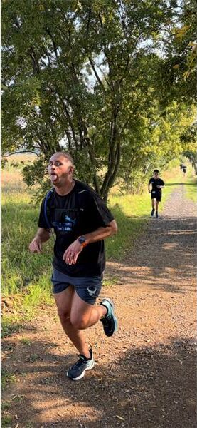 man running on a dirt road in the veld