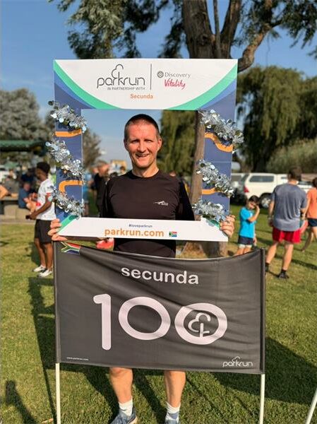 man with a 100 parkrun flag