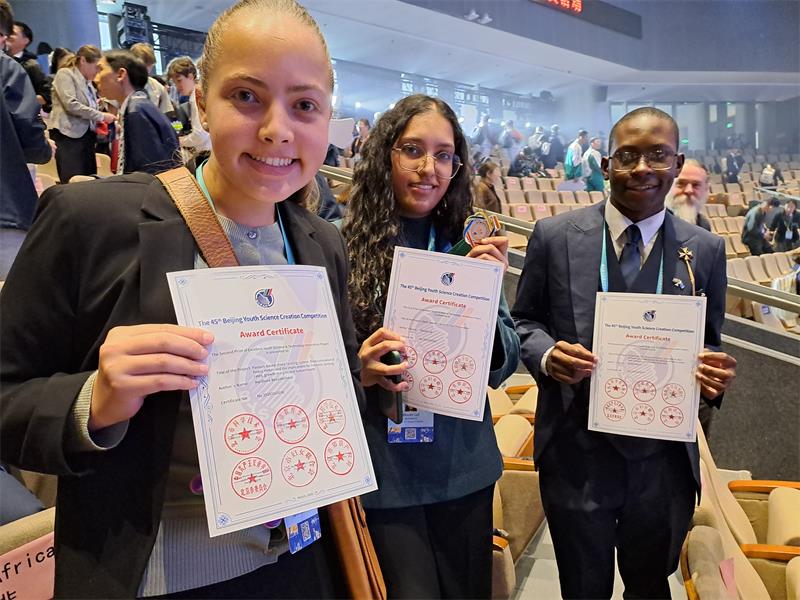 Three young people with certificates