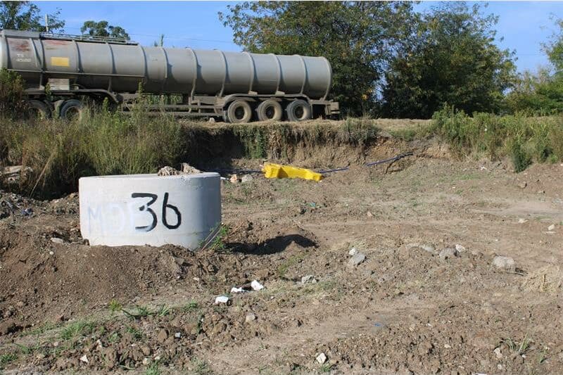 An area with ground works and a sewer manhole with the number 36 on it.