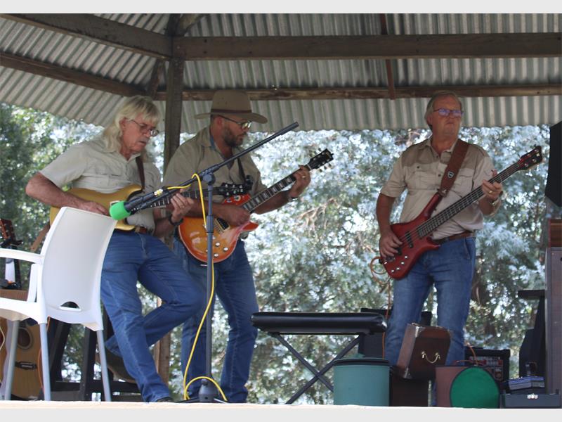 Die mans staan op n verhoog en speel kitaar