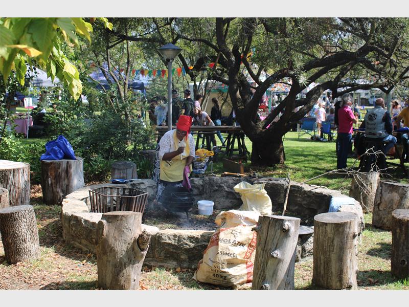 'n persoon maak in die buitelug kos