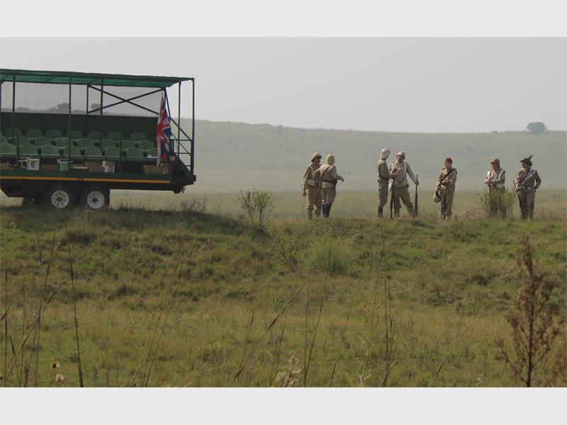 s 'n trekker en mense in die klere van Britse soldate in die veld