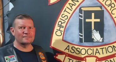 A biker standing in front of a bikers logo