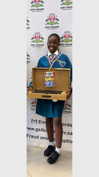 A girl in school uniform holds up a new laptop