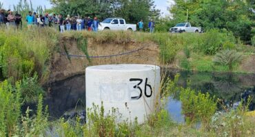 a sewer pipe inlet with a a dam filled with water