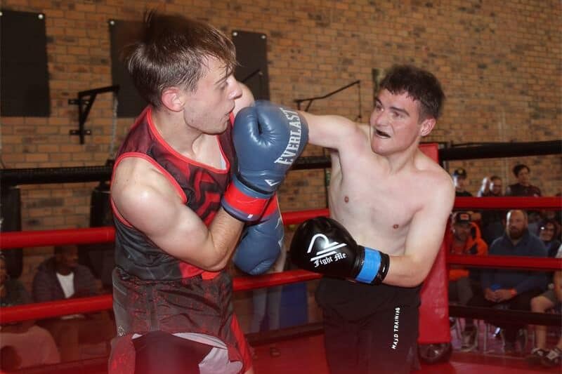 two young men in the middle of a boxing bout
