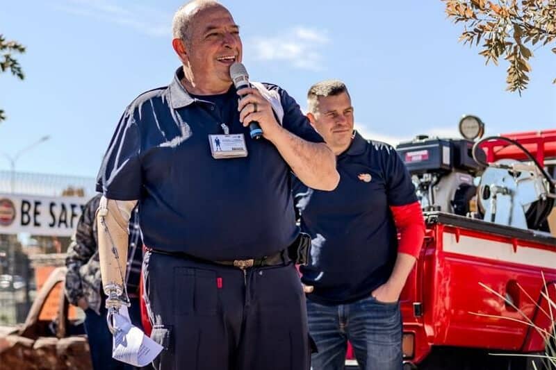 a man in a blue uniform speaks over a microphone