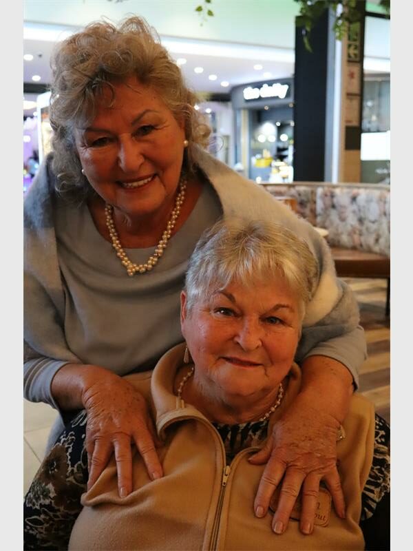 a woman with her arms around another woman