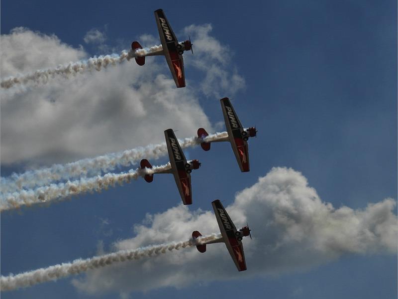 four acrobatic aeroplanes in the sky