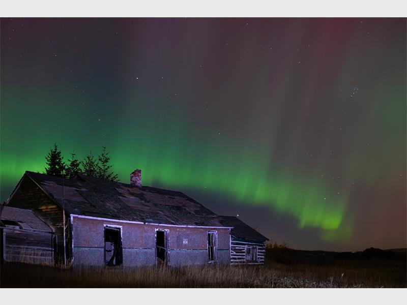 northern lights over a house