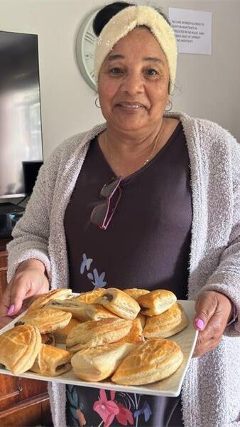 woman holding out a tray of sandwiches
