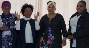 Four women standing next to each other
