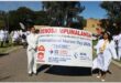 people march in the street with a poster