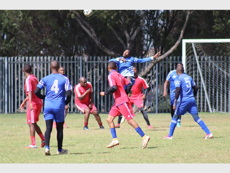 soccer teams in red and blue vie for the ball