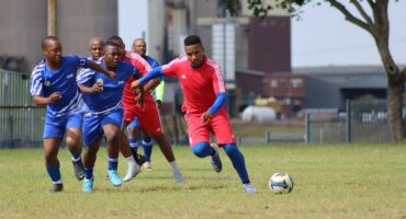soccer teams in red and blue vie for the ball