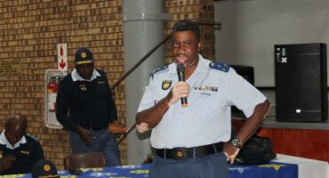 man in police uniform speaks into a microphone